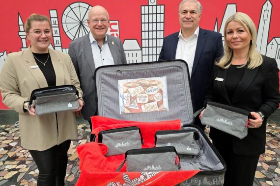 Bürgermeister und Sparkassenvertreter präsentieren Kulturtaschen als Dankeschön für ehrenamtliches Engagement.