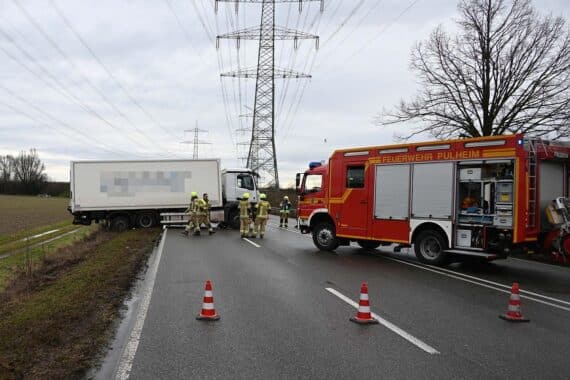 Abgerutschter LKW im Straßengraben, Feuerwehr im Einsatz zur Sicherung und Bergung.