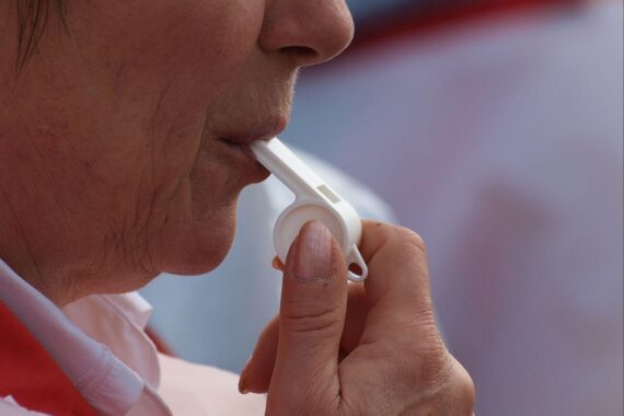 Demonstranten mit Schildern, die gegen geplante Arbeitszeitgesetzänderungen und für Arbeitnehmerrechte protestieren.