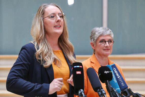 Zwei weibliche Politikerinnen der Grünen diskutieren über das Mercosur-Handelsabkommen in einem politischen Kontext.