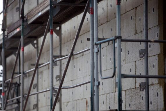 Ein Gerüst, das für Wärmedämmungsarbeiten bei einem Bauprojekt vorbereitet ist.