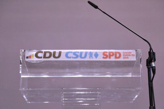 Rednerpult mit Logos von CDU, CSU und SPD, symbolisiert politische Veränderungen und Mitgliederverlust.