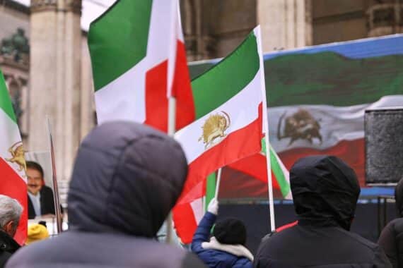 Eine Protestkundgebung mit Plakaten gegen Abschiebungen in den Iran. Menschen fordern Menschenrechte.