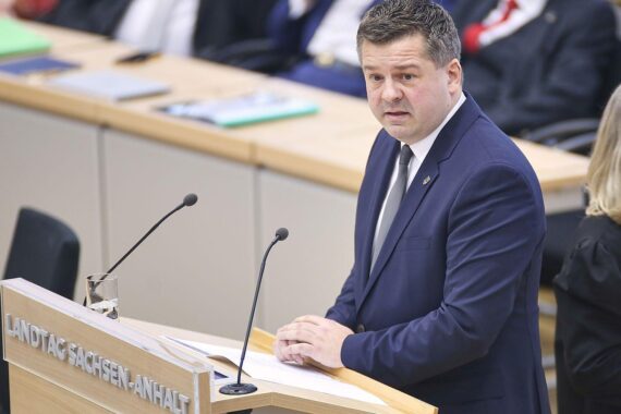 Sven Schulze spricht; politische Kontroversen im Hintergrund; Fokus auf soziale Gerechtigkeit und Vertrauen.