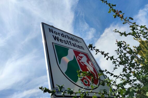 Ein Landesschild von Nordrhein-Westfalen mit dem Hinweis auf juristischen Nachwuchs und Justiz.