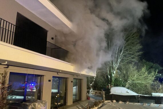 Brandrauch dringt aus einem Einfamilienhaus, Feuerwehr im Einsatz, verletzte Person.