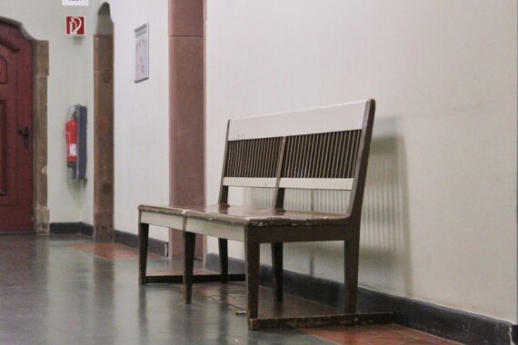 Sitzbank im Gericht zeigt Herausforderungen der Justiz: Personalmangel und digitale Rückstände.