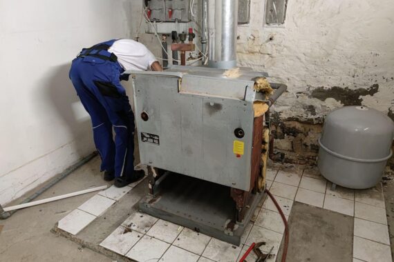 Handwerker bei der Modernisierung einer Gasheizung, symbolisiert Lohnerhöhung und Bedeutung der Branche.