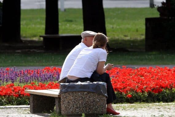 Alter Mann übergibt symbolisch ein Erbe an junge Frau, repräsentiert generationsübergreifenden Wandel in Erbschaftsteuer.