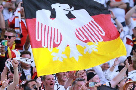Fans der deutschen Nationalmannschaft jubeln, drehen Fahnen, symbolisieren Leidenschaft für die WM-Bewerbung 2042.