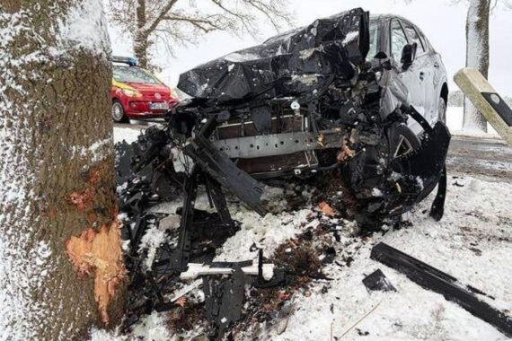 Schwerer Autounfall auf winterglatter Straße, Fahrzeug kollidiert mit Baum, Fahrer verletzt.