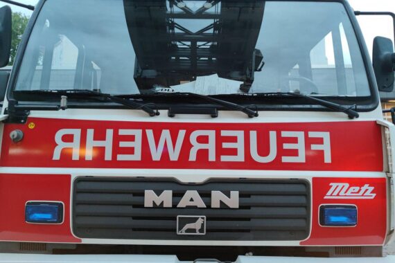 Feuerwehrfahrzeug vor Mehrfamilienhaus; Rettungseinsatz nach Brand. Verletzter Mann im Krankenhaus.