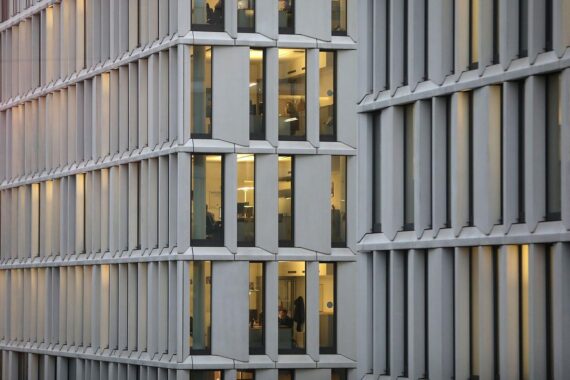 Angst vor Arbeitsplatzverlust: Besorgte Arbeitnehmer in modernen Büros, reflektierende Mienen und angespannte Atmosphäre.