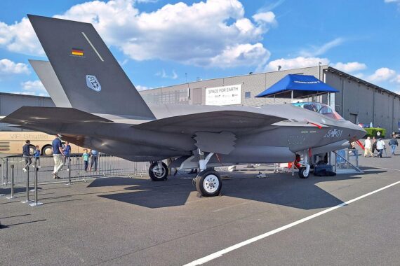 F-35A Kampfjet über symbolischem Hintergrund zur militärischen Abhängigkeit Deutschlands von den USA.