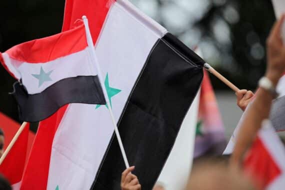 Eine syrische Flagge im Kontext einer friedlichen Demonstration gegen Angriffe auf Zivilisten.