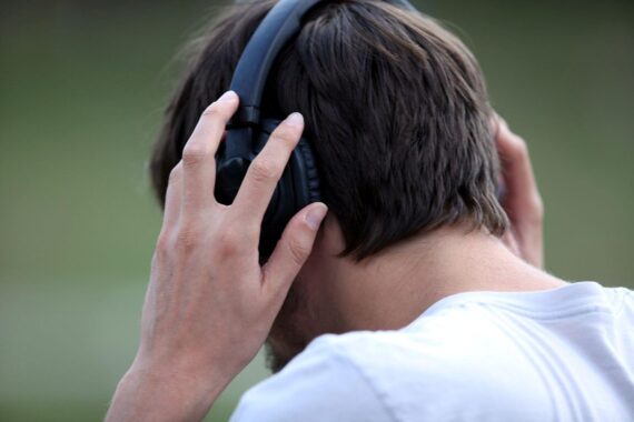 Mann mit Kopfhörern genießt Musik, symbolisiert den Erfolg von "Versengold" in den Charts.