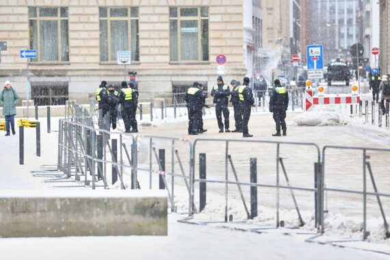 Polizei sichert abgesperrte, schneebedeckte Straße bei winterlichen Bedingungen in Hamburg.