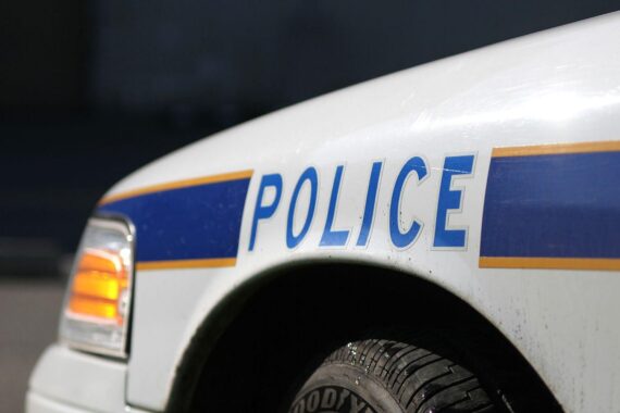 US-Polizeiauto vor einem kritischen Hintergrund, symbolisiert aktuelle Gewalt durch Polizeieinsätze in Minneapolis.