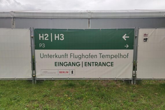 Flüchtlingsunterkunft mit emotionalen Gesichtern, symbolisiert Abschiebungen und Herausforderungen der Migration.