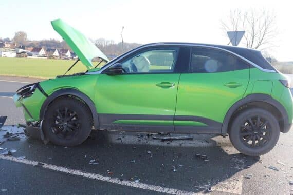 Zwei beschädigte Autos nach Unfall, Airbags ausgelöst, Polizei und Rettungswagen vor Ort.