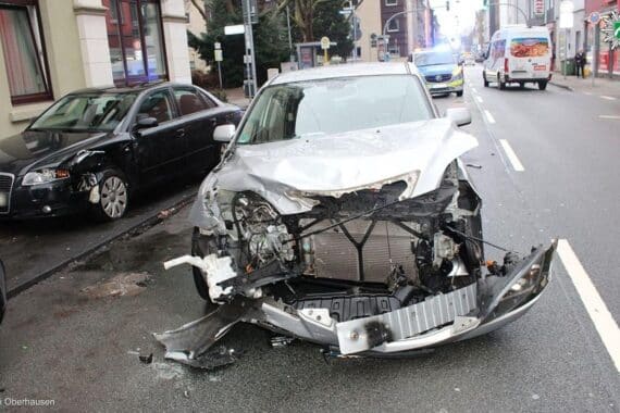 Zwei beschädigte Autos nach Kreuzungsunfall; Polizei und Rettungskräfte sind vor Ort.
