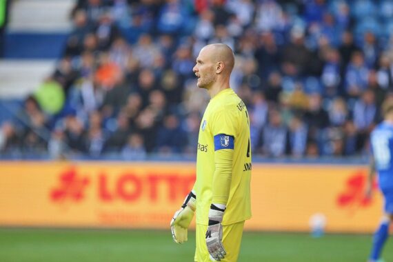 Schalke-Spieler feiern Tor, während Magdeburgs Spieler enttäuscht zusehen, mit spannendem Spielhintergrund.