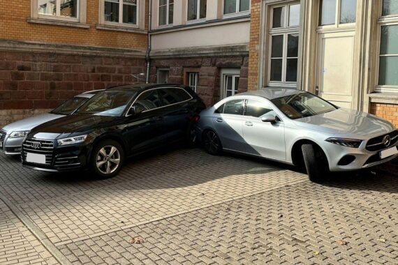 Unfallstelle mit beschädigten Fahrzeugen: Mercedes, Audi-SUV, Hauswand; hoher Sachschaden, keine Verletzten.