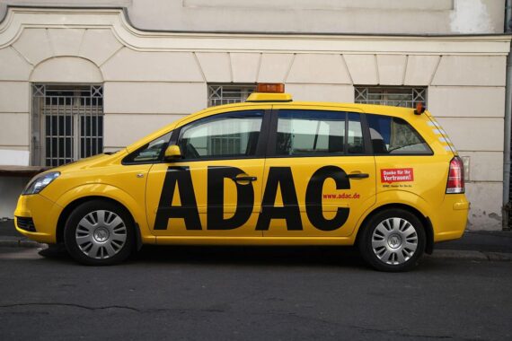 ADAC-Logo mit Rücktrittsankündigung und Mitgliederaustritten, symbolisiert durch enttäuschte Autofahrer.
