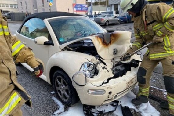Auffahrunfall: brennendes Auto, Feuerwehr im Einsatz, Polizei vor Ort, Personen vor Krankenhaus.