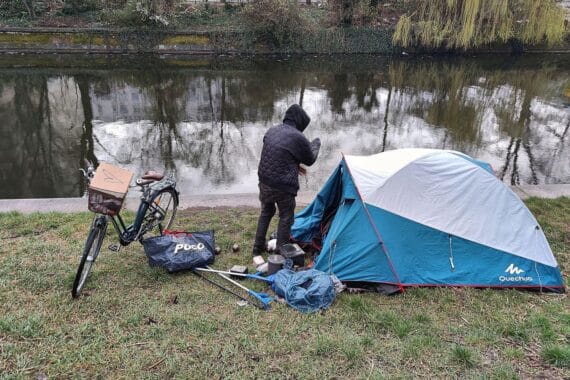 Obdachlose mit Zelten in einer Stadtstraße, Symbol für Wohnungslosigkeit und Mietrechtsproblematik.