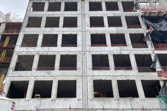 Bürokratieabbau: Baustelle mit Baustellenfahrzeugen und Menschen, symbolisiert die Notwendigkeit von Veränderungen.
