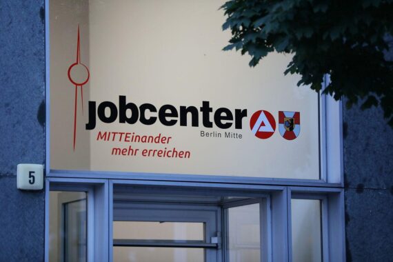 Ein Jobcenter mit Menschen, die Hilfe suchen und Informationen zum Arbeitsmarkt erhalten.