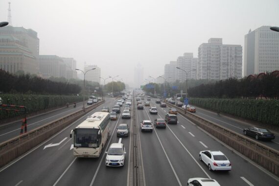 Rasch fahrende Fahrzeuge in Peking, symbolisieren den geschäftigen Straßenverkehr und wirtschaftliche Beziehungen.