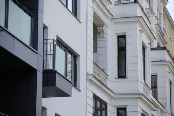 Hausfassade mit Hinweis auf steigende Mieten durch neue Krankenkassen- und Pflegebeiträge.