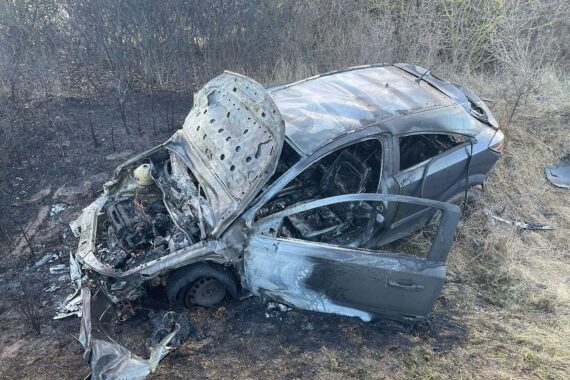 Ausgebranntes Auto im Straßengraben, Feuerwehr im Einsatz, geschehener Verkehrsunfall, verletzte Fahrer.
