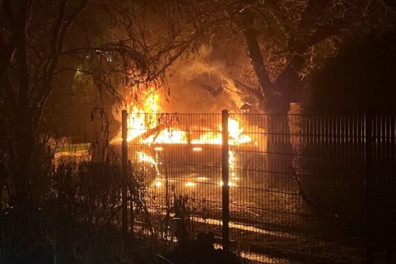 Brennender Audi im Garten, Feuerwehr löscht, Polizeieinsatz vor Ort, Ermittlungen zur Brandursache.