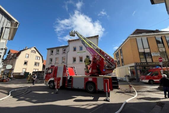 Drehleiter der Feuerwehr kontrolliert Dach eines Hauses nach Ofenbrandgeruch in Weinheim.