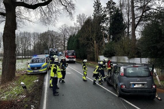 Feuerwehr Schermbeck bei Lkw-Pkw-Unfall, Einsatzkräfte sichern auslaufende Betriebsmittel ab.