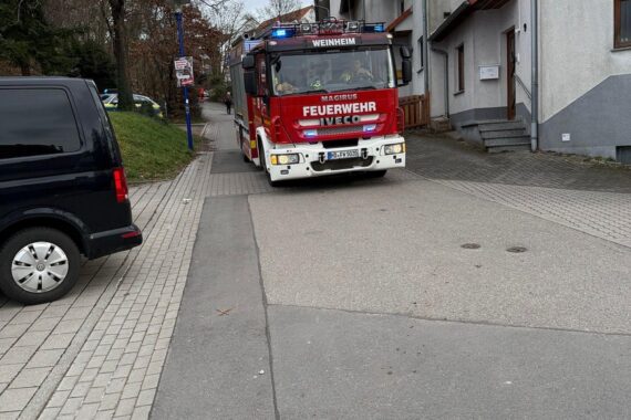 Löschfahrzeuge der Feuerwehr Weinheim in enger Zufahrtstraße, bereit für Einsatz bei Brandmeldealarm.