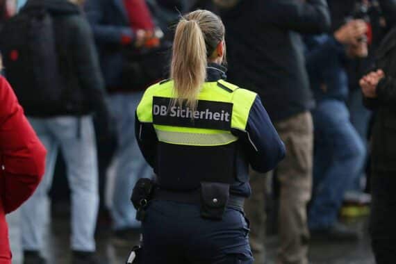 Sicherheitskräfte im Zug sichern die Reisenden, während Maßnahmen zur Verbesserung der Bahnsicherheit erörtert werden.