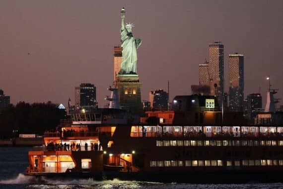 Freiheitsstatue vor amerikanischer Flagge, symbolisiert die Diskussion über Datenschutz und Reisefreiheit.