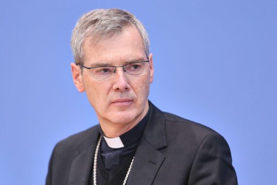 Heiner Wilmer, neuer Vorsitzender der Deutschen Bischofskonferenz, lächelnd in rotem Bischofskleid.