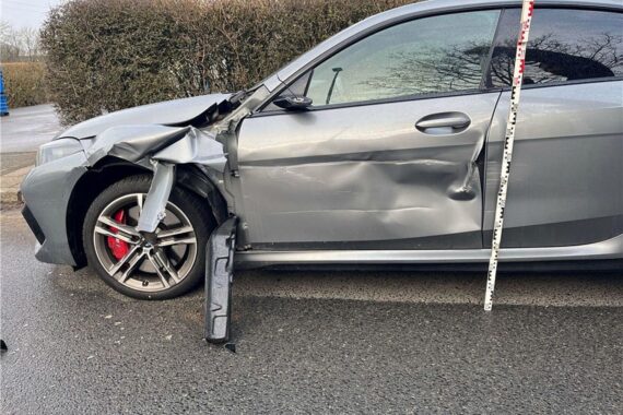 Stark beschädigter BMW nach Lkw-Unfall, Fahrer flüchtet; Polizei sucht Zeugen für Hinweise.