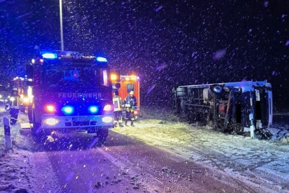 Lastwagenunfall: Fahrzeug im Graben, Feuerwehr rettet Person, Einsatzkräfte reinigen Unfallstelle.