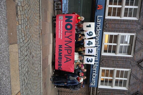Aktivisten übergeben Unterschriften gegen Olympia-Referendum in Hamburg, Protest und kritische Stimmen sichtbar.