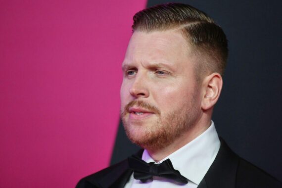 Finch reflektiert über seine Vergangenheit, symbolisiert durch Mikrofon und kritische Texte auf Papier.