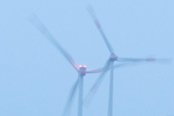 Windräder vor blauem Himmel, Symbol für den Ausbau erneuerbarer Energien in Deutschland.