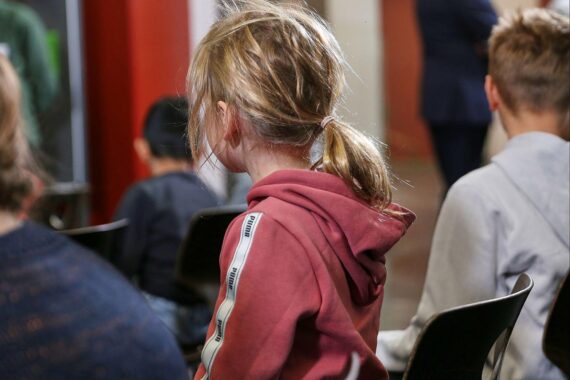 Kinder in einer Schule, symbolisieren stabile Betreuung und verlässliche Elternbeiträge für Familien.