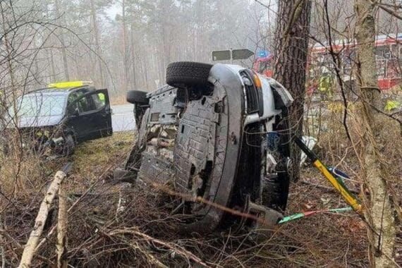 Schwerer Verkehrsunfall mit umgekipptem Auto, Feuerwehr im Einsatz, Verletzte werden behandelt.