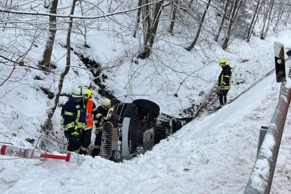 Rettungskräfte bergen Verletzte nach schwerem Verkehrsunfall auf winterglatter Straße.